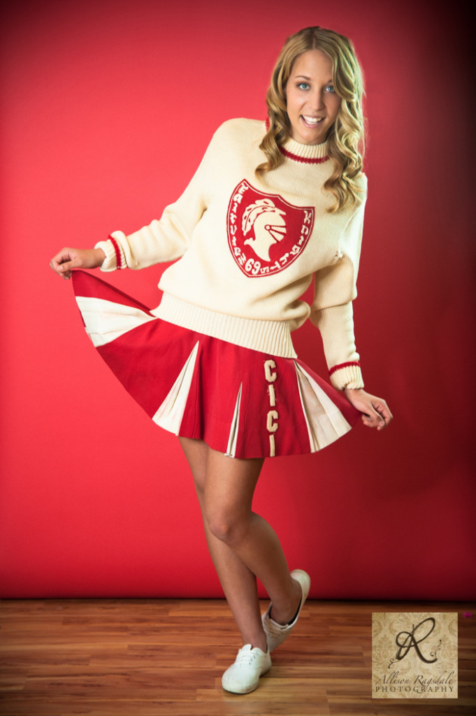vintage cheerleader uniform senior pic in studio red backdrop