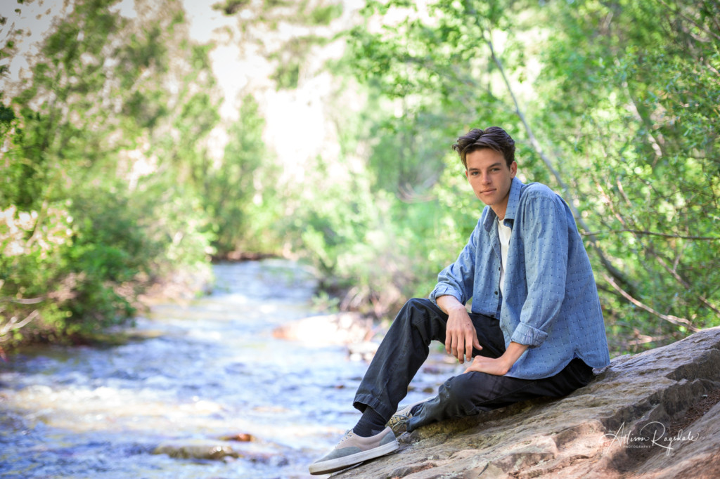 Senior pictures of guy by river