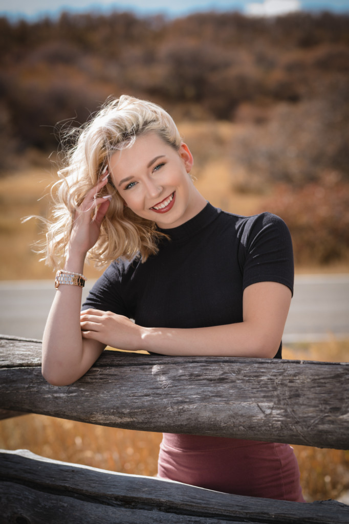 girl senior photo on wooden fence