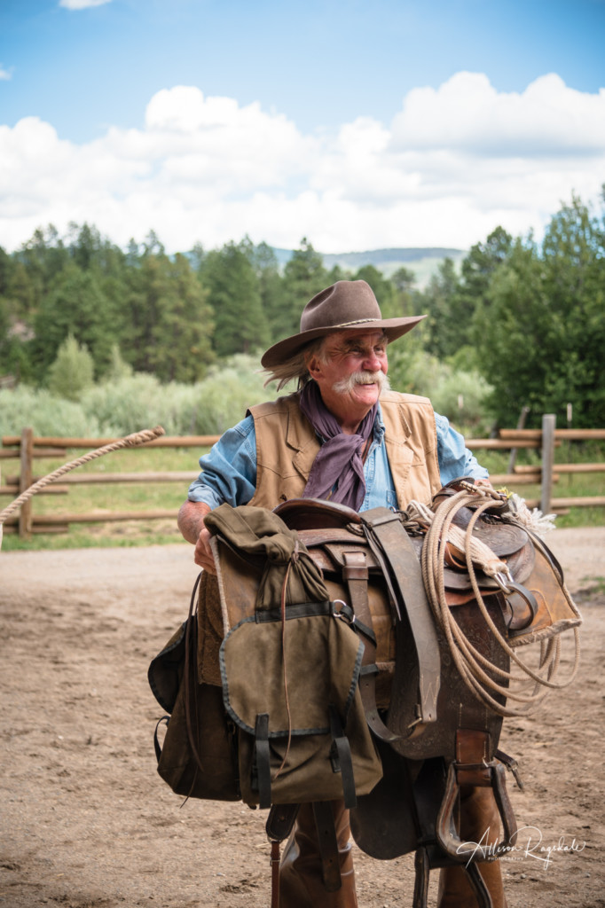 Cowboy caring saddle in Durango Colorado taken by Allison Ragsdale Photography