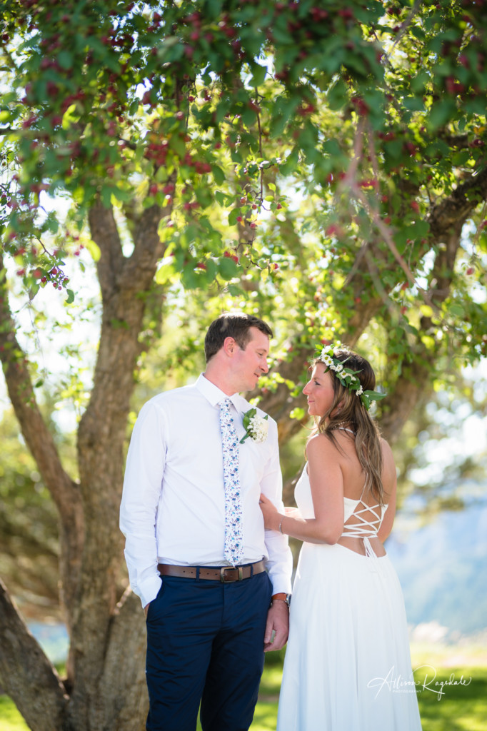 wedding bride and groom in the trees flower tie back of wedding dress