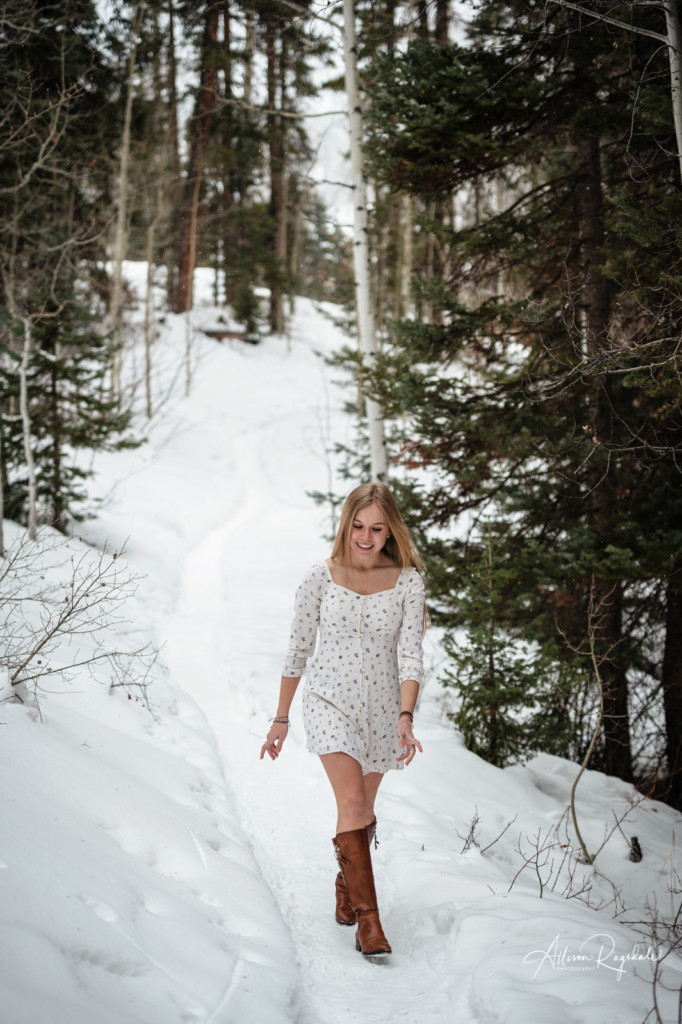 senior girl walking down snowy path colorado portrait