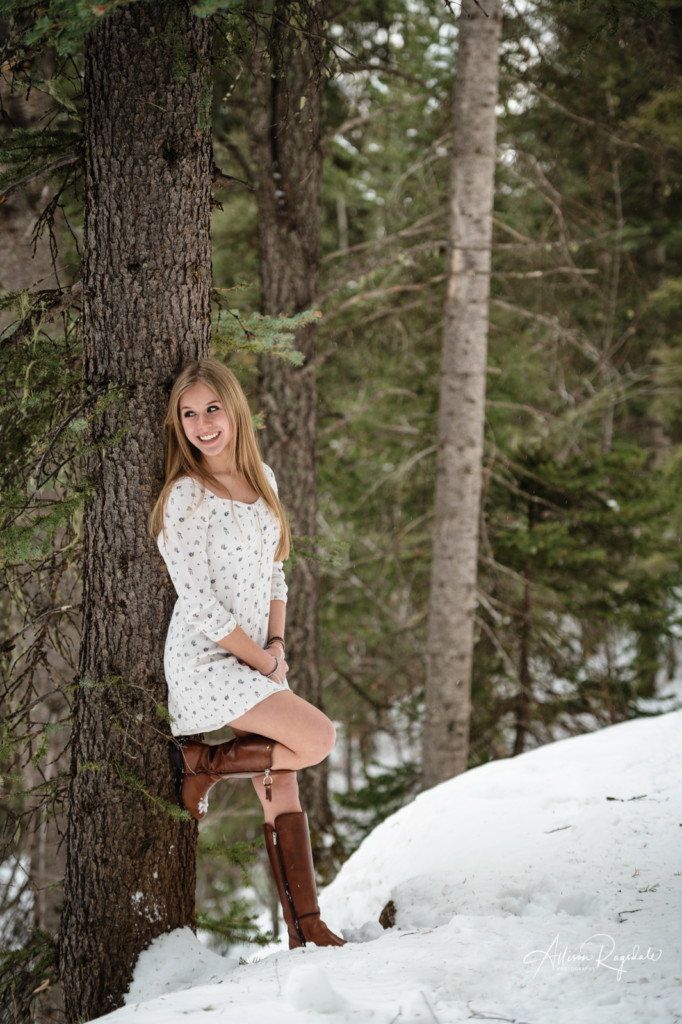 senior girl in white dress in snow and pine trees picture