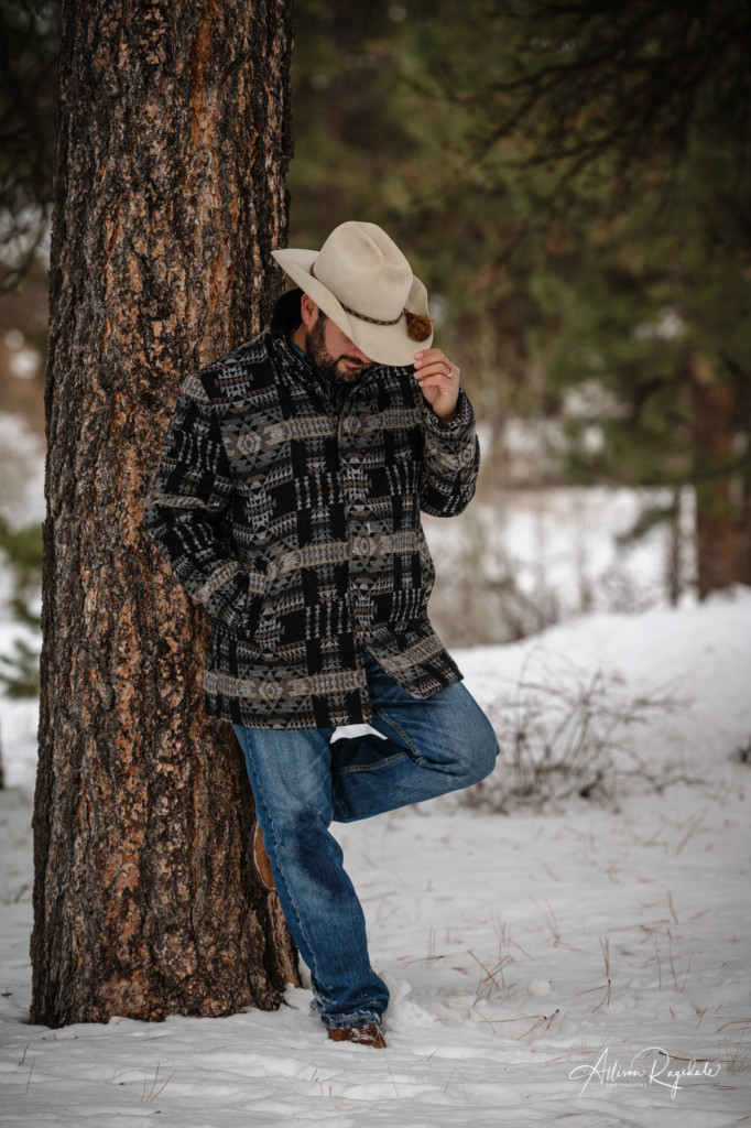 dad in cowboy hat and boots leaning against tree pic