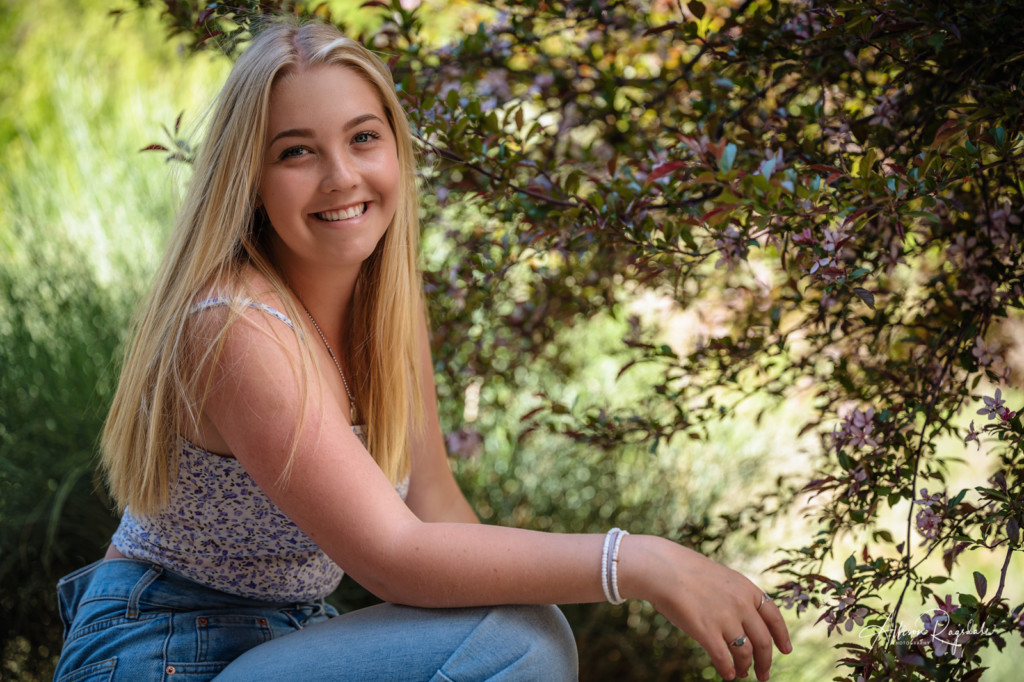 senior picture girl kneeling by spring blossoms colorado