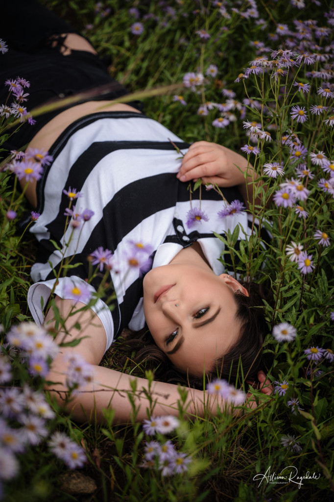 senior picture laying in purple daises