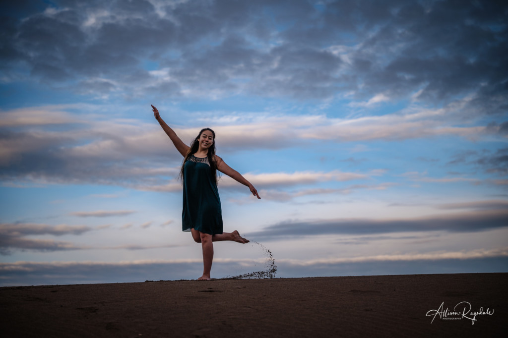 girl dancing at sand dunes at sunrise senior pic