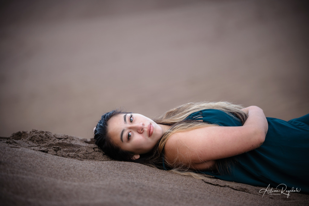 girl laying in sand senior pic