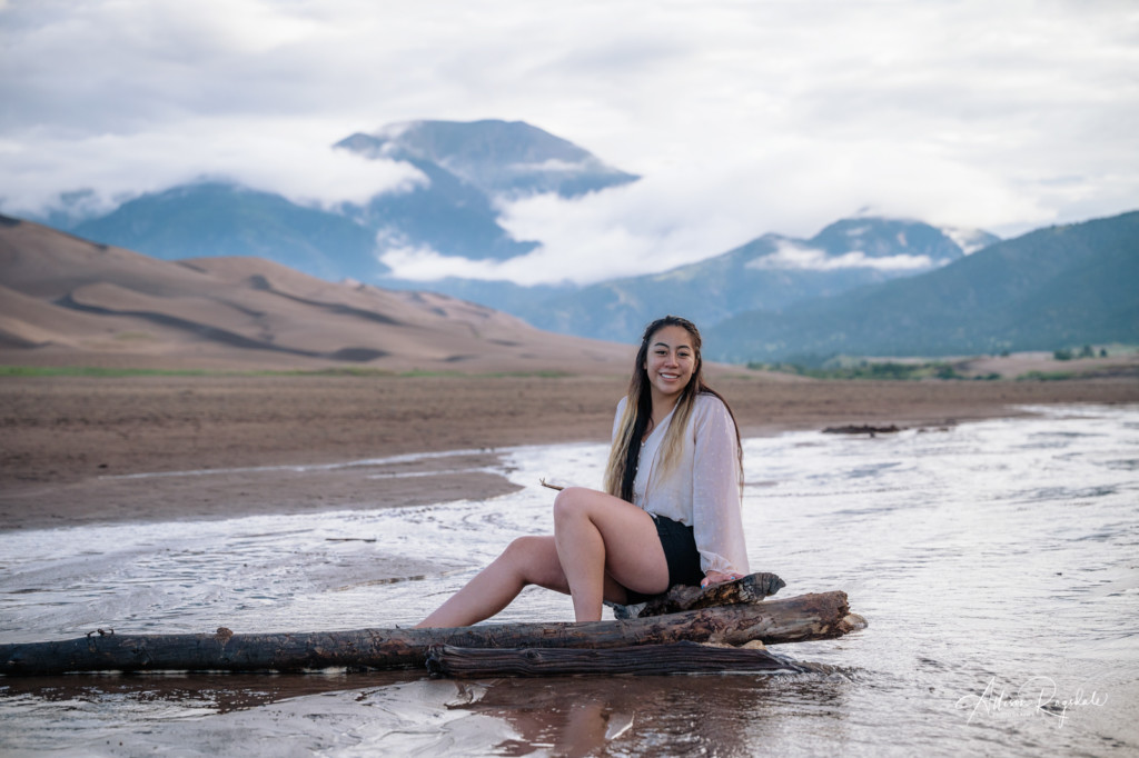 girl senior pictures at sand dunes in creek