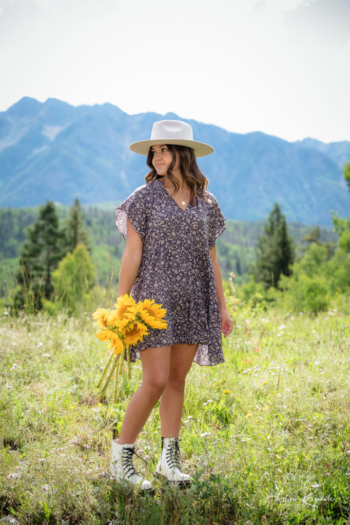 senior photo with girl in hat with sunflowers