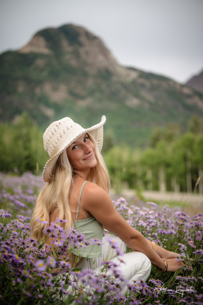 girl sitting in purple flowers mountain background senior pic