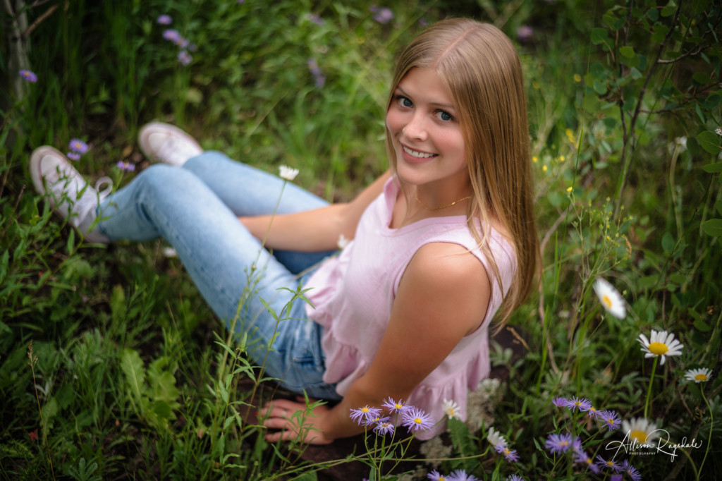 girl senior pic sitting in flowers from above