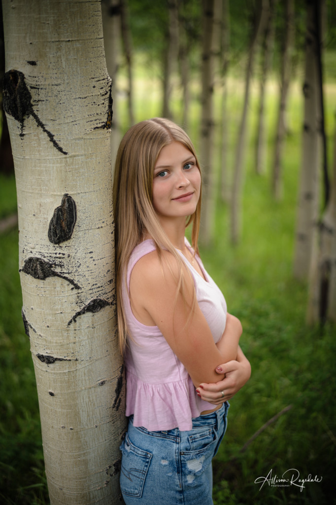 girl senior picture leaning on an aspen tree