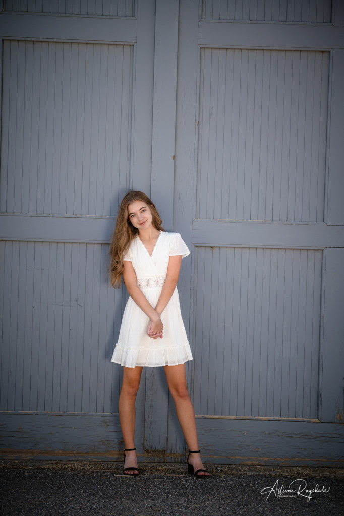 girl senior photo in front of purple gray doors