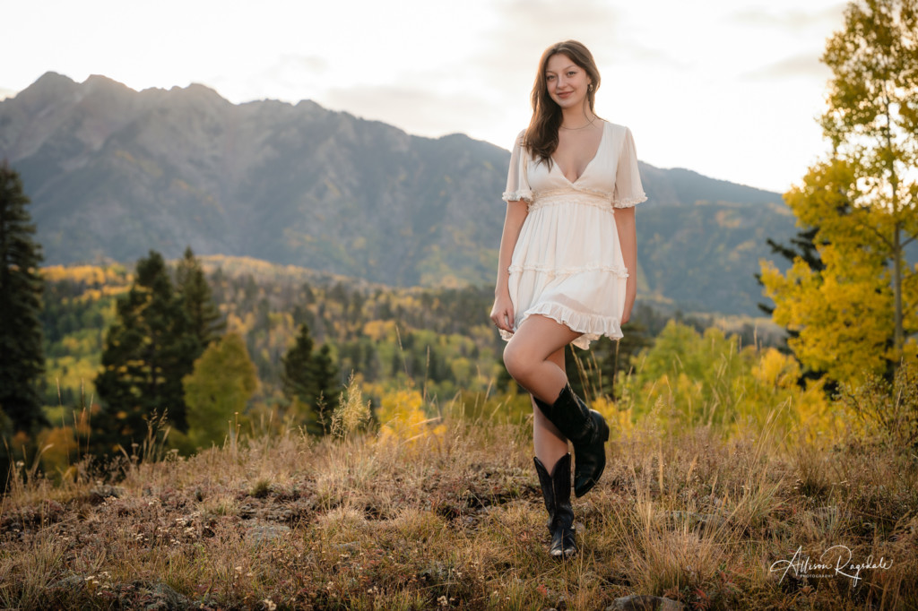 senior pic girl in white dress cowgirl boots mountains in fall