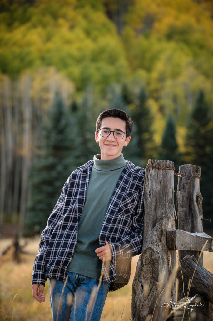 senior guy pic leaning on fence fall colors