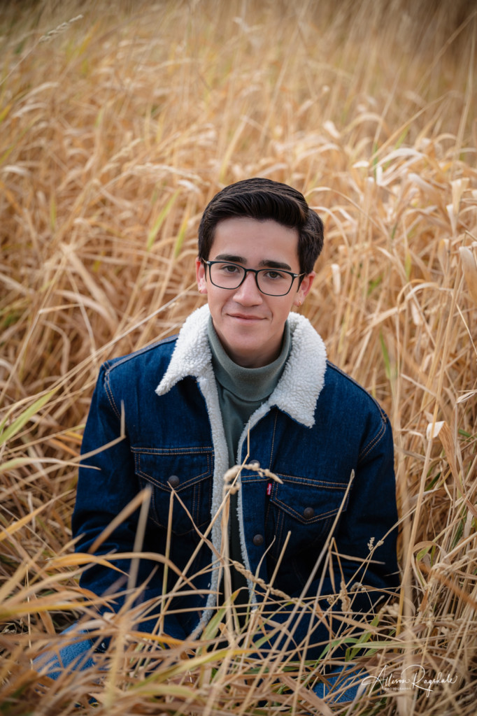 senior guy picture in long grass field denim jacket