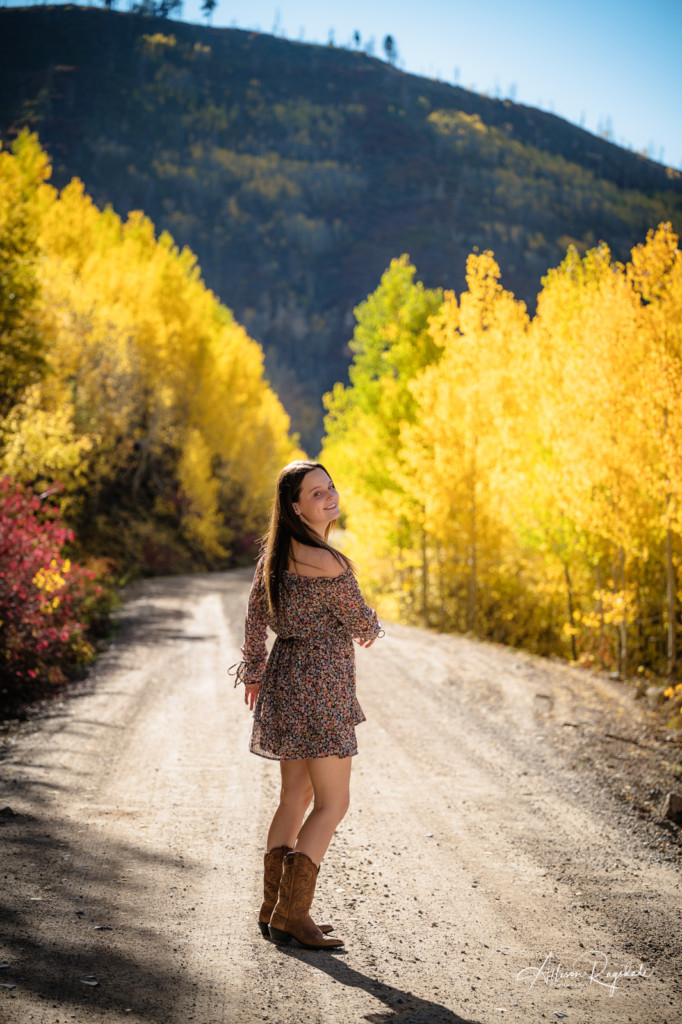 senior girl walking down dirt road fall aspens colorado picture