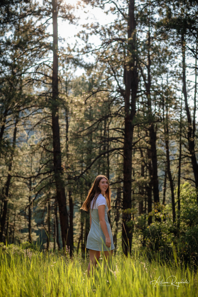 early fall girl in grass field pine tree forest senior picture