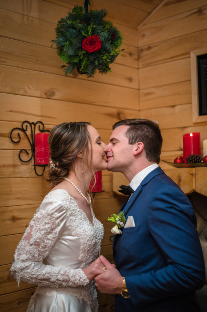 kissing under mistletoe winter wedding picture