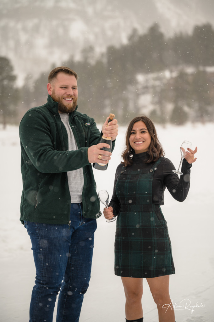 surprise proposal on ice skates couple celebrating with champagne portrait