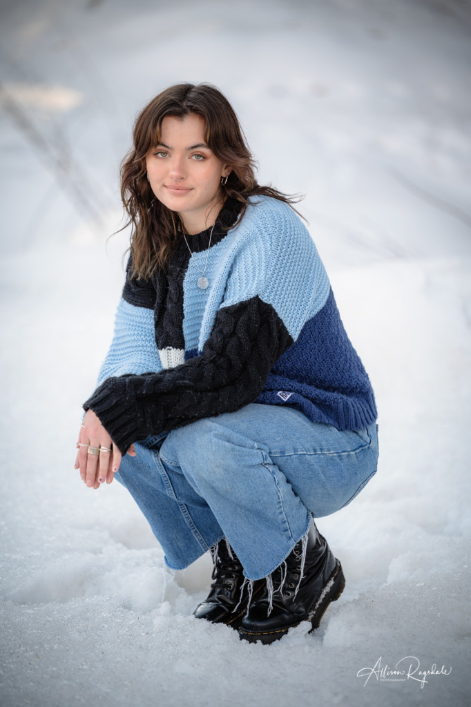 girl in snow and blue block sweater senior pic
